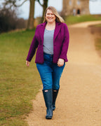 Woman in a purple coat, striped shirt, and blue jeans walking on a path outdoors.. This blazer is the Auburn Blazer sewing pattern from Cashmerette.