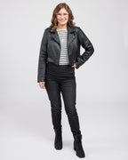 Woman wearing a black leather jacket in front of a white wall. This biker jacket is the Canton Moto Jacket sewing pattern from Cashmerette.
