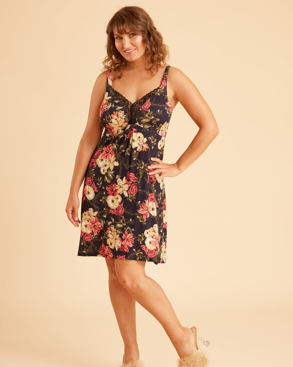 Woman wearing a floral dress on a beige background. This is the Fiske Sleepwear Set sewing pattern from Cashmerette.
