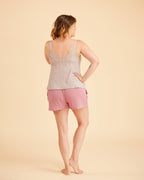 Woman wearing a patterned tank top and pink shorts on a beige background. This is the Fiske Sleepwear Set sewing pattern from Cashmerette.