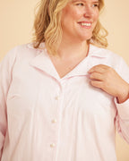 Woman wearing a light pink shirt against a beige background. This is the Fiske Sleepwear Set sewing pattern from Cashmerette.