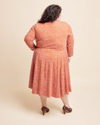 Woman wearing a patterned dress on a beige background. This is the Grafton Dress, Top & Skirt sewing pattern from Cashmerette.