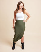 Woman wearing a white top and green skirt on a beige background. This is the Grafton Dress, Top & Skirt sewing pattern from Cashmrette.