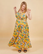 Woman wearing a yellow floral dress against a beige background. This is the Holyoke Maxi Dress & Skirt sewing pattern from Cashmerette.