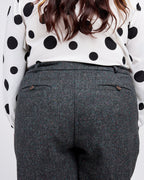Person wearing a polka dot blouse and gray pants on a white background. These pants are the Meriam Trousers sewing pattern from Cashmerette.