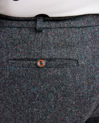 Close-up of a gray textured fabric with a button on a white background. These pants are the Meriam Trousers sewing pattern from Cashmerette.