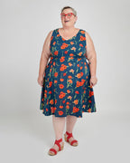 Woman wearing a blue dress with red floral pattern on a white background. This dress is the Upton Dress & Skirt sewing pattern from Cashmerette.