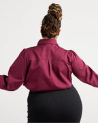 Person wearing a burgundy shirt with long sleeves on a white background. This top is the Vernon Shirt sewing pattern from Cashmerette.